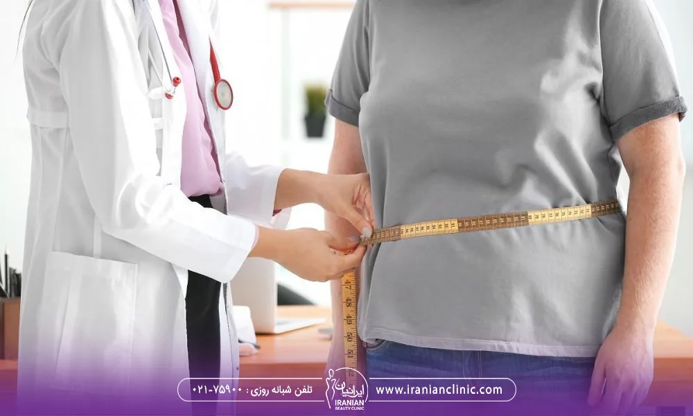 پزشکی که در کلینیک لاغری دور شکم مراجعه کننده دچار چاقی را اندازه می گیرد - مرکز لاغری