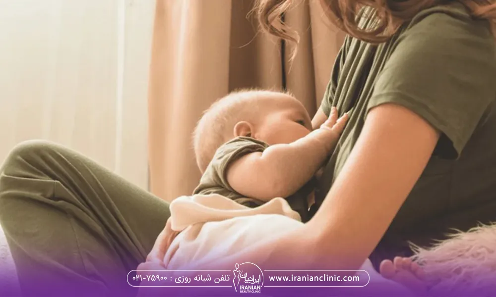 یک خانم که روی تخت نشته و در حال بچه شیر دادن است