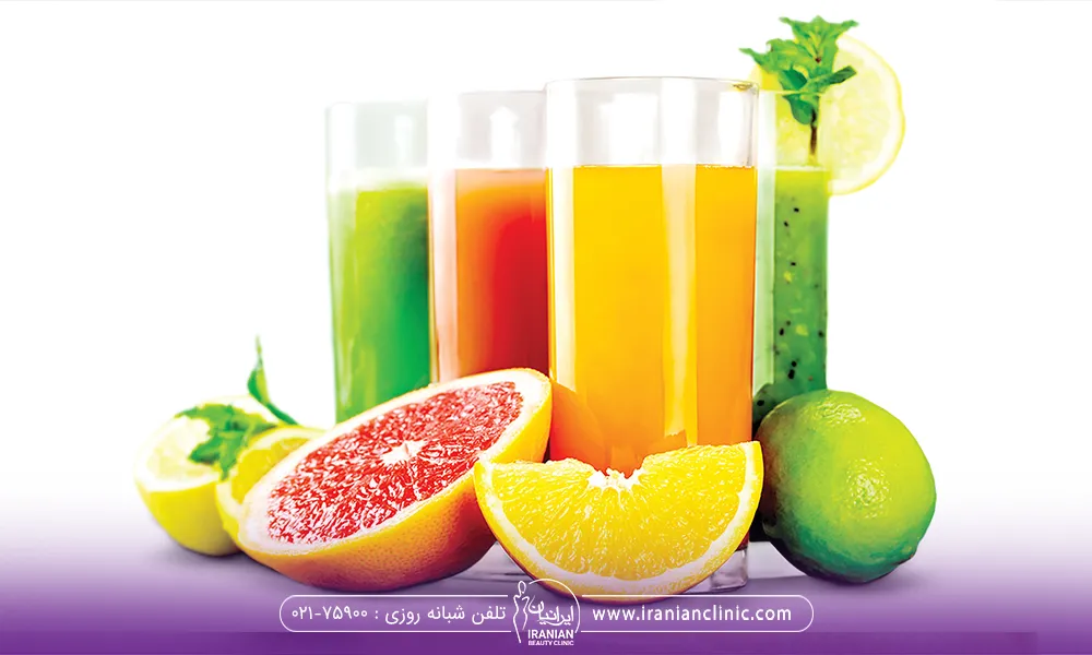 3 لیوان ابمیوه طبیعی و چند تا میوه برش خورده روی زمین قرار دادر
