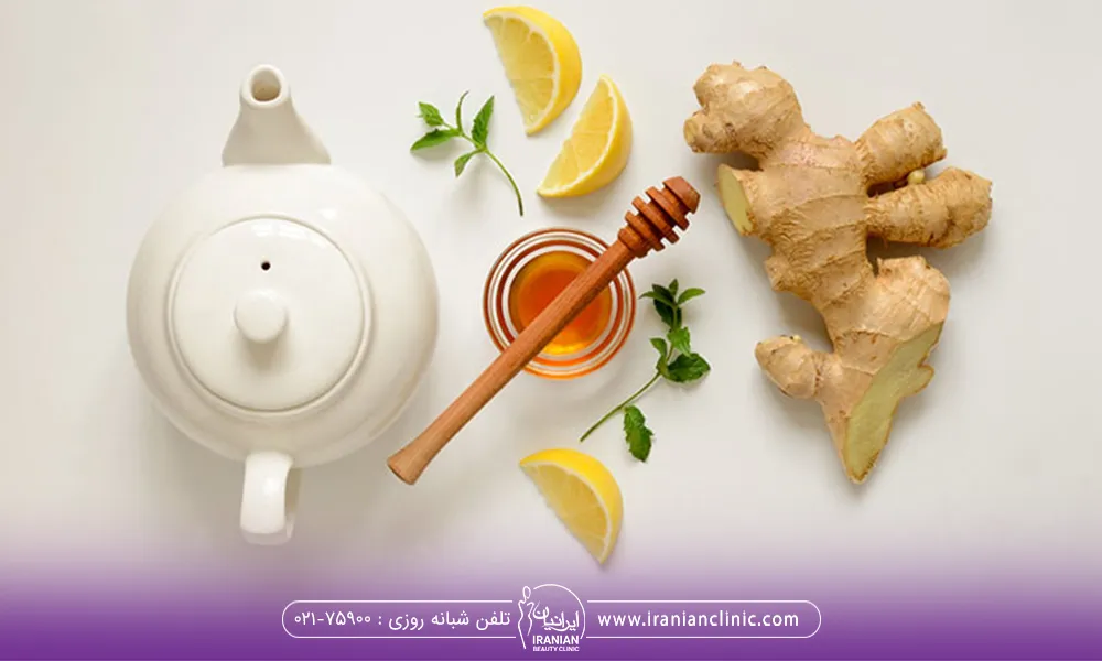 قرار گرفتن فنجان لیمو قوری زنجبیل عسل برای درست کردن چای زنجبیل برای لاغری