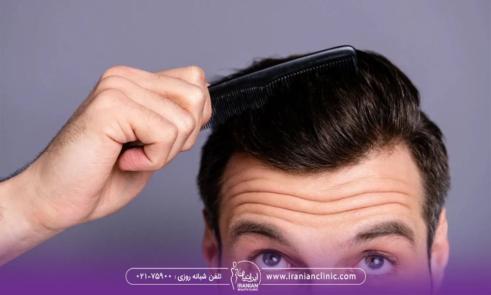 مردی که به بالا نگاه می کند و موهای خود را شانه می کشد