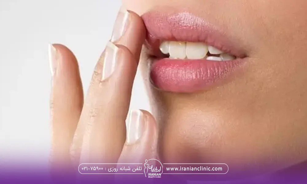 عکس نزدیک از لب های دختری که انگشت خود را روی لب بالایش گذاشته است - زود جذب شدن ژل لب