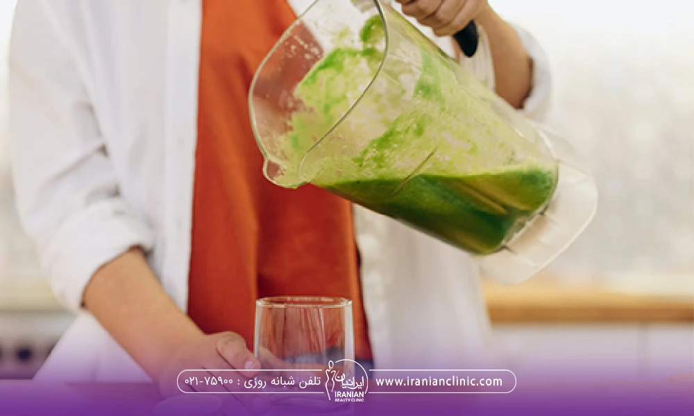 فردی که در حال ریختن نوشیدنی گیاهی از پارچ به لیوان است - معجون لاغری سریع شکم